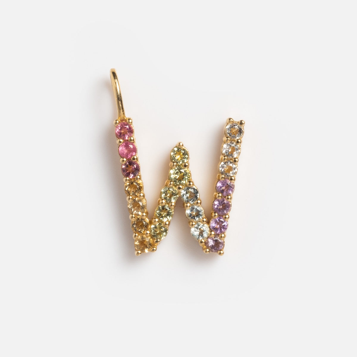 The Solid Gold Pastel Gemstone Letter Charm Sample is a W-shaped 9k yellow gold pendant adorned with small multicolored gemstones, including pink tourmaline, shown against a white background.