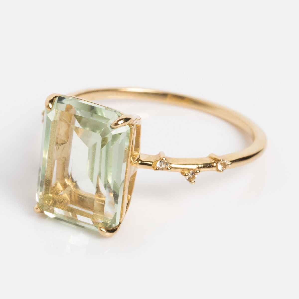 The Solid Gold Dewdrop Green Amethyst Statement Ring features a large rectangular pale green gemstone in a prong setting, with branch-like details and tiny accent stones for a striking look.