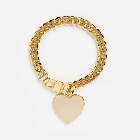 The Julian XL Heart Cuban Chain Bracelet in 18k gold plating features a flat polished heart charm and chunky clasp, elegantly displayed on a white background.