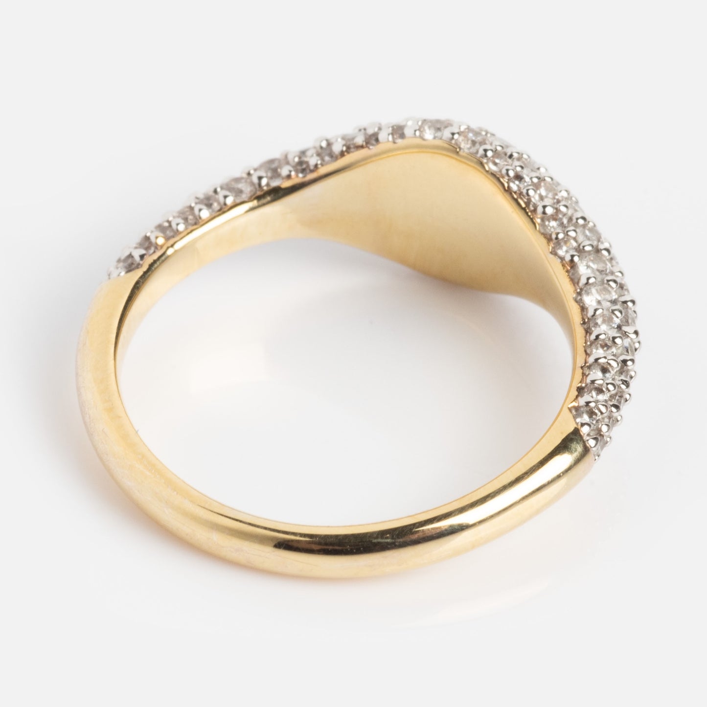 The Pave Signet Pinky Ring features a wave-shaped gold design adorned with small white gemstones along the raised edge, shown against a plain white background.