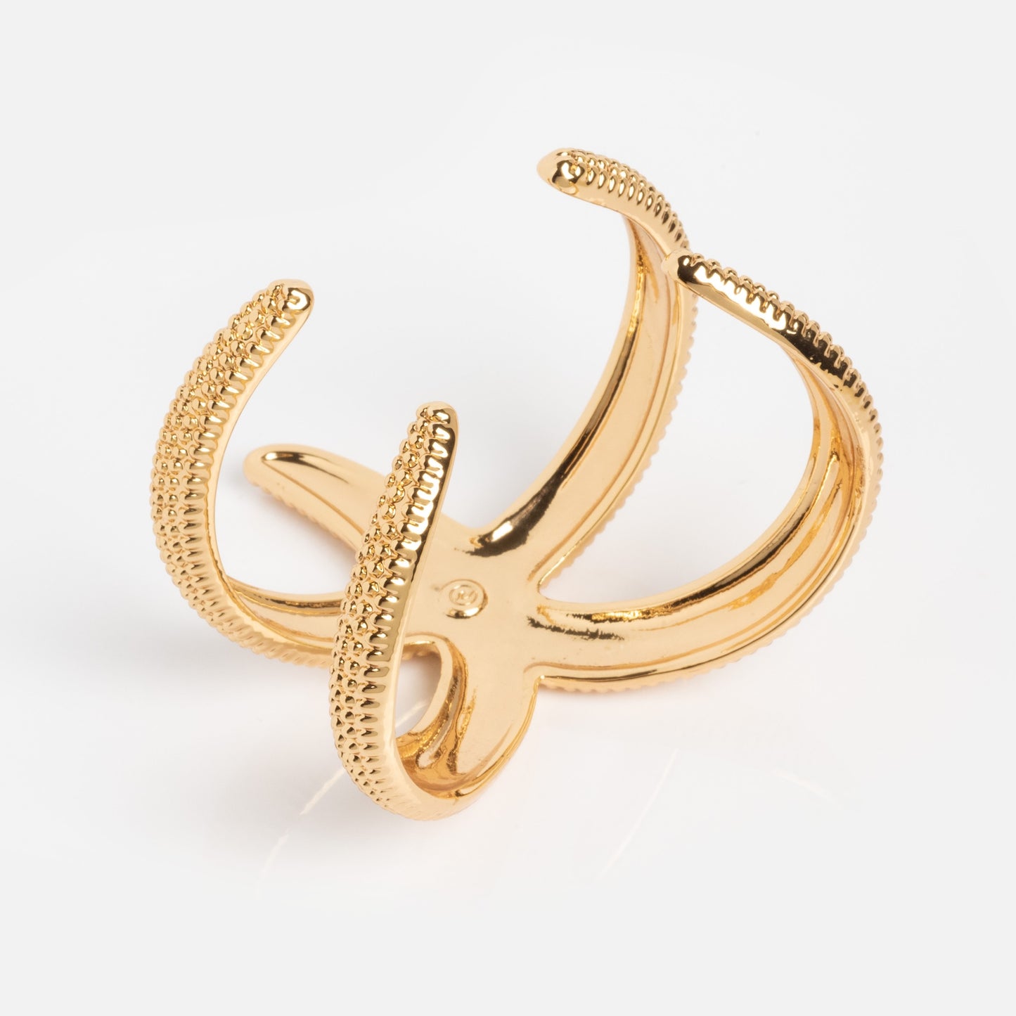 A golden Nautilus Shell Cuff with detailed, textured curves, photographed on a plain white background.