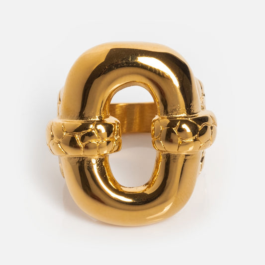 The Caruso Ring is a chunky, gold-plated ring featuring bold interlocking oval links, a polished reflective surface, and intricate detailing on its connecting sections.