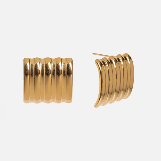 The Mari Earrings are gold statement earrings with a ridged, wavy design, displayed from the front and side against a plain white background.