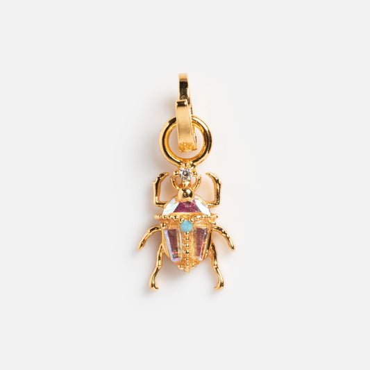 The Charms by Girls Crew Beetlejuice Charm features an 18k yellow gold beetle-shaped pendant with detailed legs and an iridescent gemstone body, displayed against a plain white background.