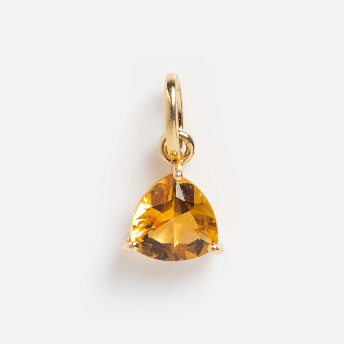 The Solid Gold Trillion Birthstone Charm features a faceted triangular gemstone set in 9k yellow gold with three prongs and a small gold loop—ideal for necklaces or bracelets. Presented on a plain white background.