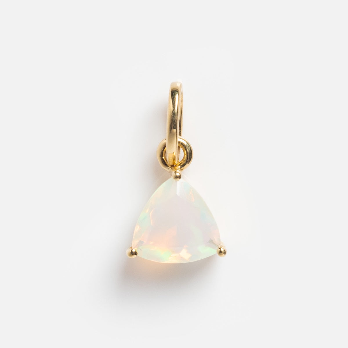The Solid Gold Trillion Birthstone Charm features a trillion cut opal with iridescent hues, secured by three prongs on a small 9k yellow gold loop, set against a plain white background.