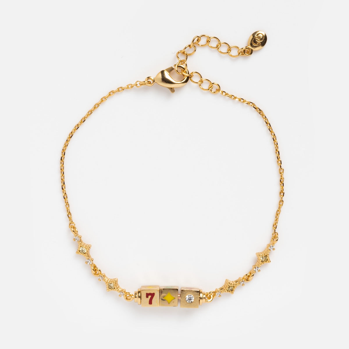 The Hit The Jackpot Bracelet by Girls Crew showcases a gold chain with star charms and three central beads, including a red number 7 die—all plated in 18k yellow gold—displayed on a white background.