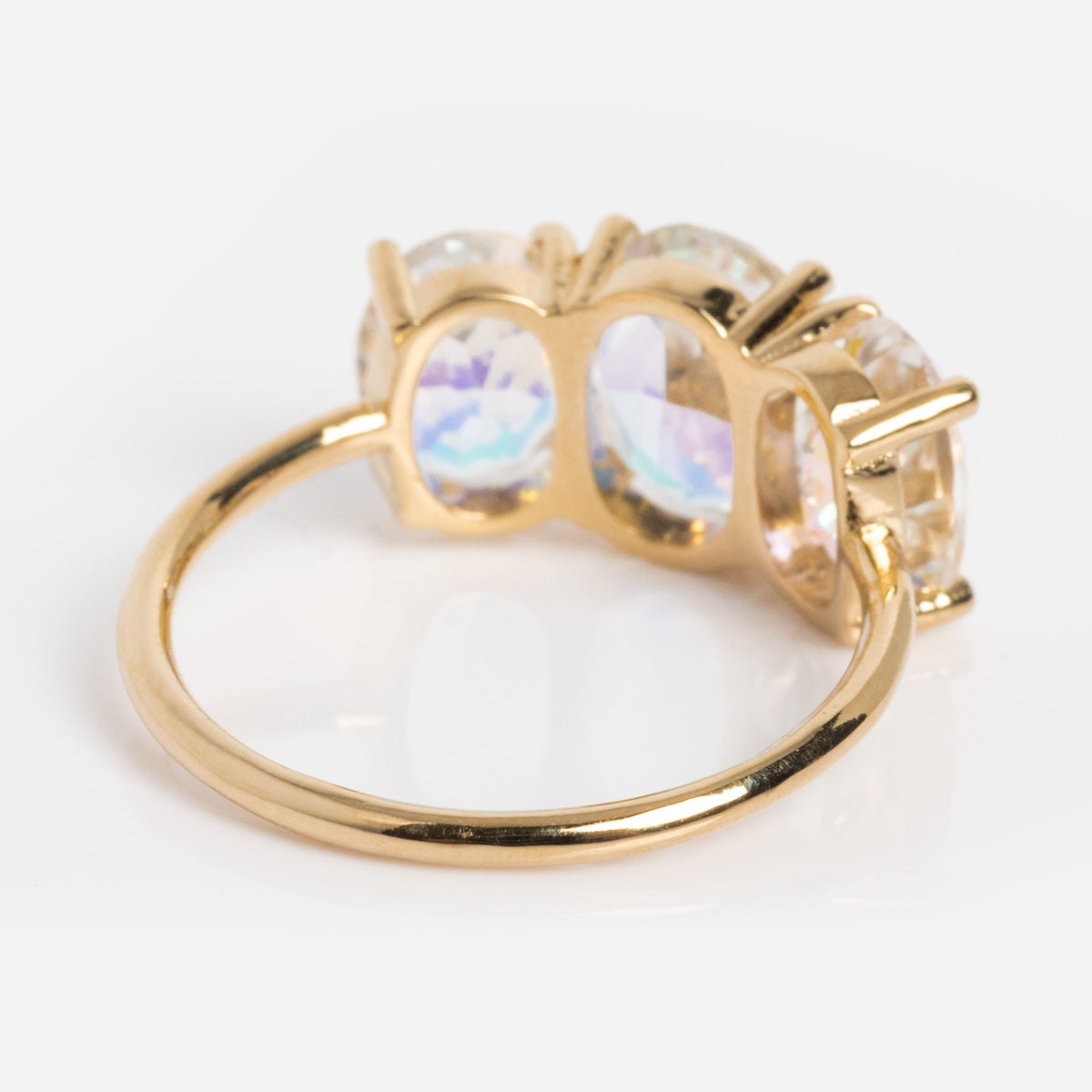 The One of a Kind 14k Angel Aura Gumdrop Ring showcases three oval iridescent gemstones in a prong setting, displayed from the side on a white background.