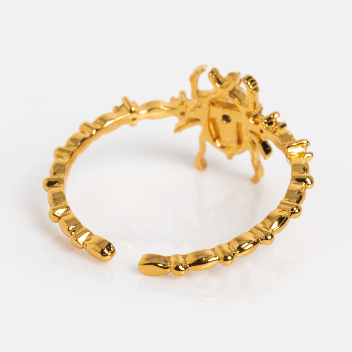 The Beetlejuice Ring features a gold open band with a textured, irregular design and a beetle-shaped top accented by iridescent CZ stones, shown on a white background.