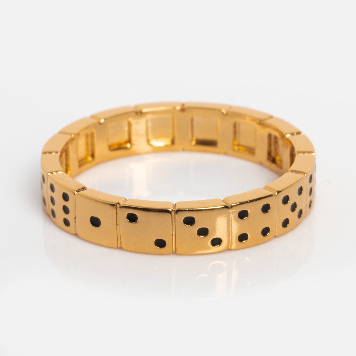The 777 Ring is a gold-plated ring styled like domino tiles, with black dots for numbers on each segment. Displayed on a white background, this unique piece makes a striking addition to any lucky jewelry collection.