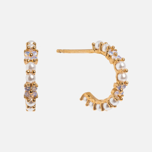 The Orchid Pearl Hoops are small gold-plated earrings with white pearls and light purple gemstones in a delicate gold frame, displayed from front and side angles on a white background.
