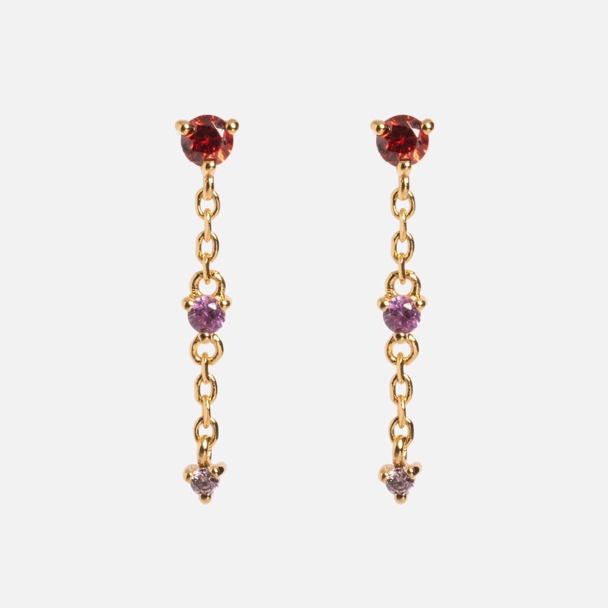 The Celebration Ombre Birthstone Drop Studs feature 14k gold plating, with red and purple gemstones linked by delicate chains—perfect personalized jewelry.