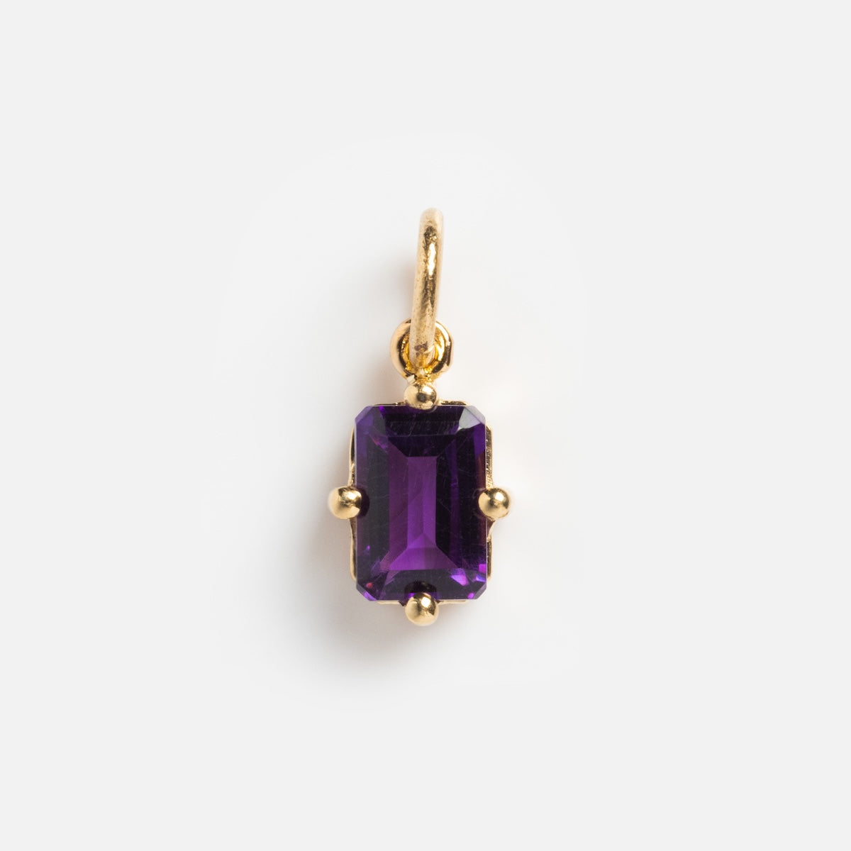 The 14k Mod Love Birthstone Charm features a rectangular, faceted purple gemstone baguette set in a gold prong pendant with a gold loop, shown against a plain white background.