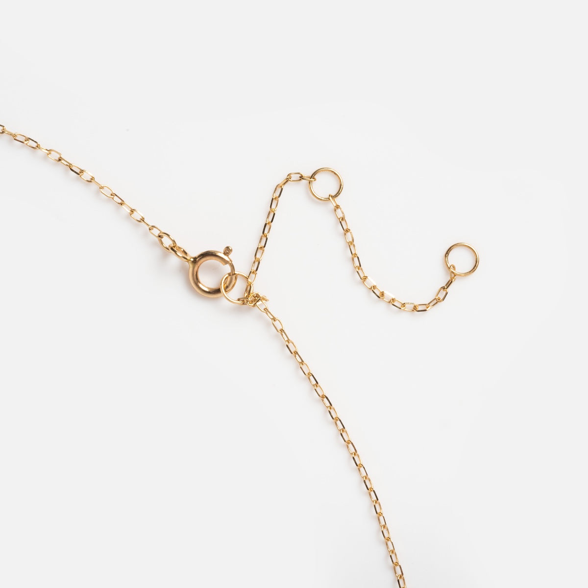 The Solid Gold 2025 May Capsule Vintage Inspired Emerald Pendant Necklace features a delicate gold chain with a spring ring clasp and two open circular links, beautifully displayed on a plain white background.