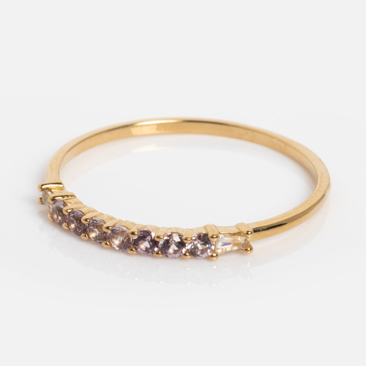 The Solid Gold 2025 June Capsule Delicate Alexandrite Stacking Ring features a row of seven light purple round alexandrites set on a slim band—perfect as a June birthstone or stacking ring, shown on a white background.