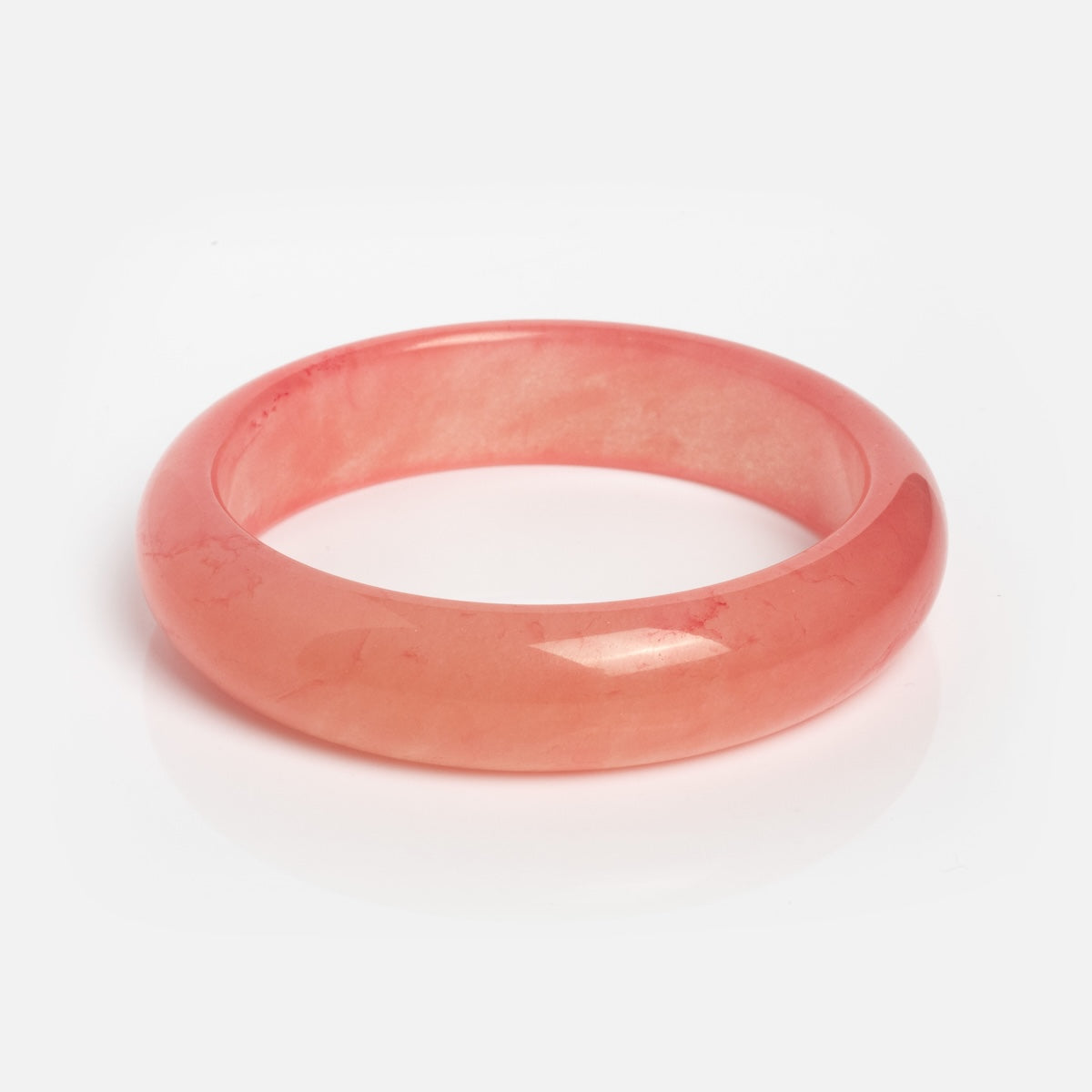 A Pink Quartzite Bangle, ideal for stacking with other bracelets, is elegantly displayed on a white background.