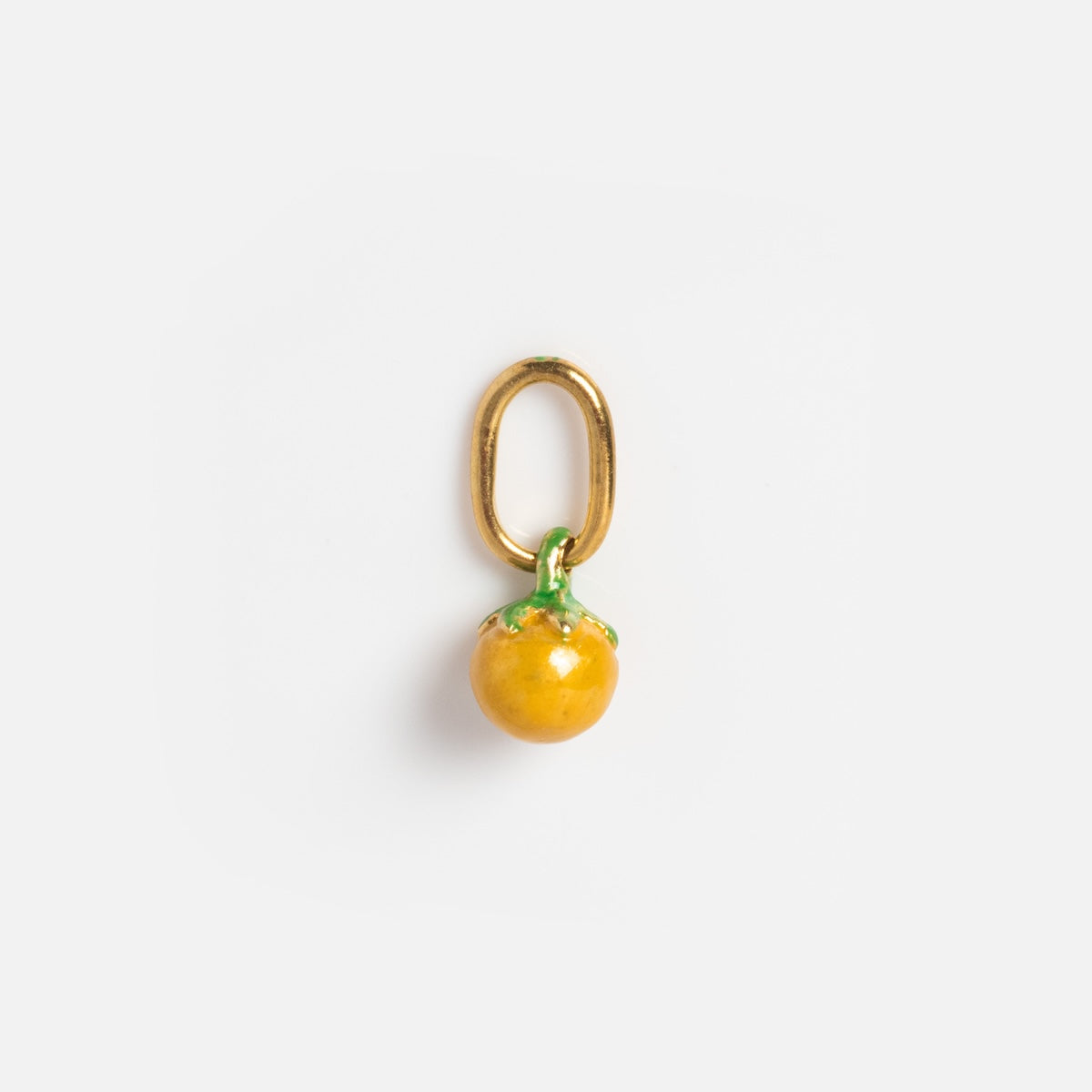 Charms by Satomi Studio: A small gold keychain or pendant with a glossy yellow enamel fruit charm and green top, resembling a tomato or orange, displayed on a plain white background.