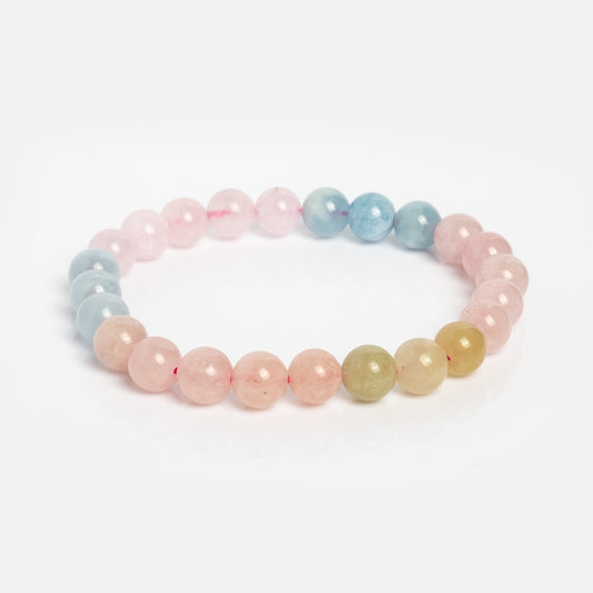 The Billie Beaded Crystal Bracelet features round, polished crystals in pink, blue, and light yellow gradient tones on a stretch cord, shown against a white background.