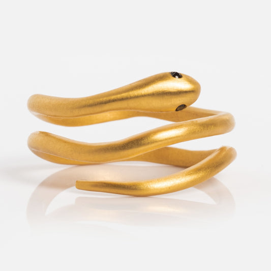 The Black Spinel Snake Ring, crafted in 18k gold plated metal, showcases a coiled snake design with black stone eyes. This adjustable ring combines elegance and versatility, making it a standout accessory.