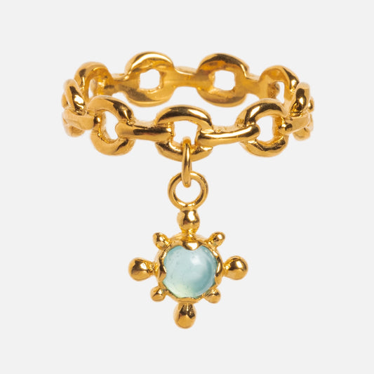 The Chain Charm Ring in 18k gold vermeil features an open chain-link design and a dangling starburst charm with a light blue agate ring at its center.