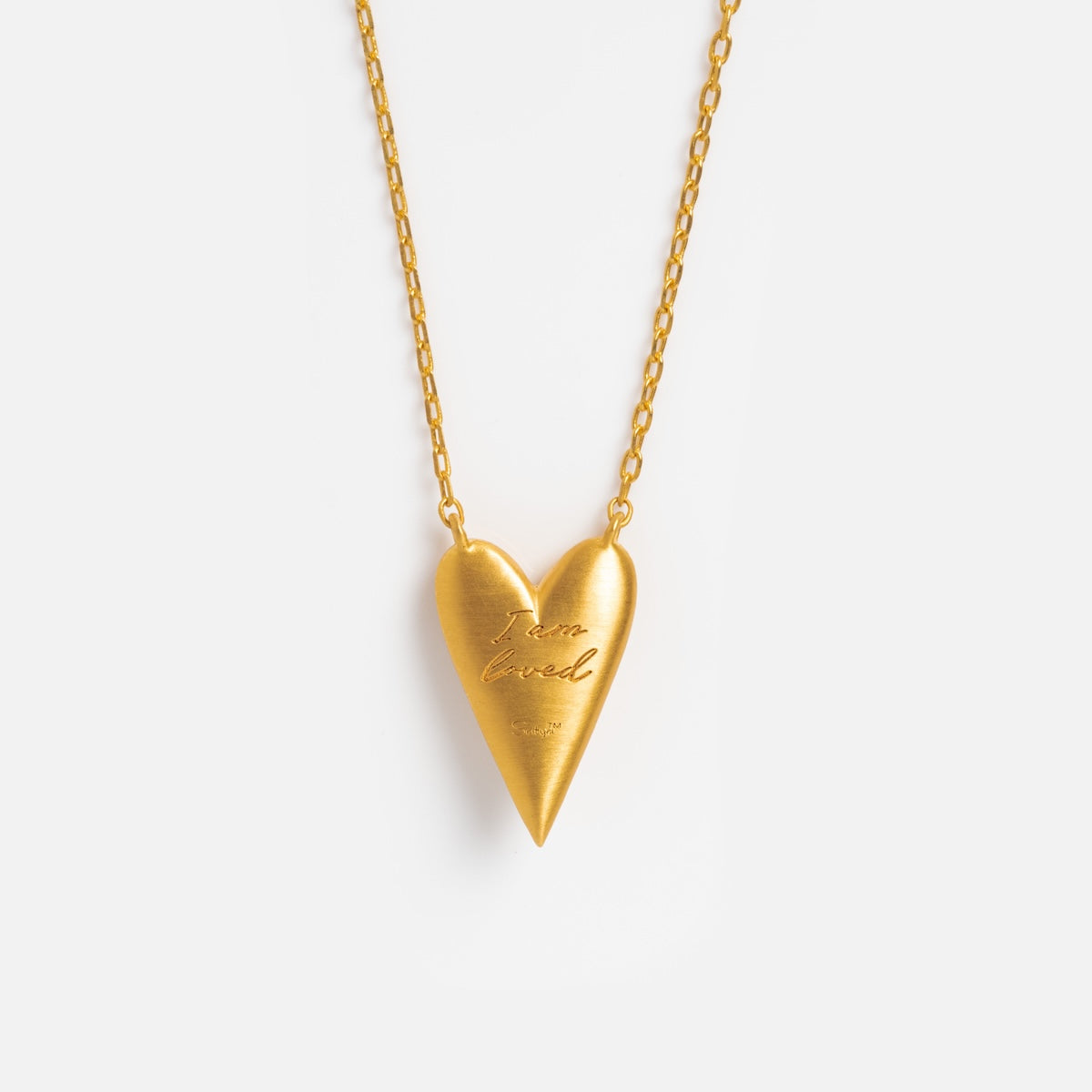 The I Am Loved Heart Necklace features a gold heart pendant engraved with I am loved and adorned with sparkling white topaz, shown against a plain white background.
