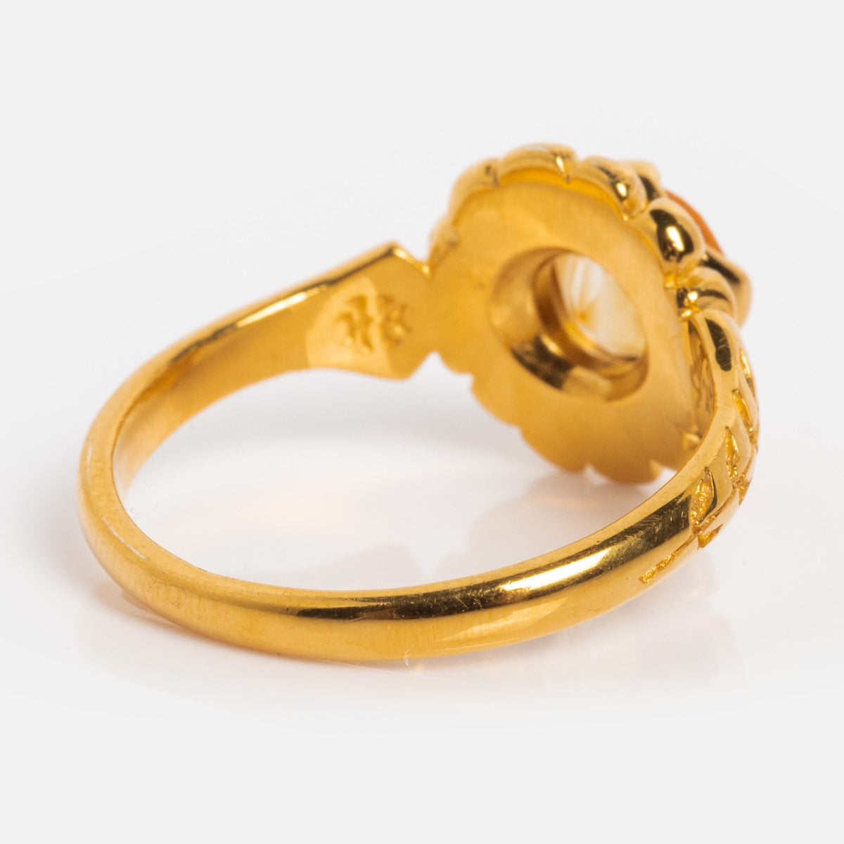 The Bloom Solitaire Ring in yellow gold vermeil, with a round floral-shaped setting and hollow back, is shown from the side to highlight its elegant band against a white background.