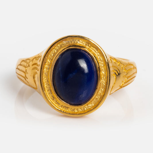 The Astral Ring is a gold vermeil band engraved with wings, highlighted by an oval deep blue lapis stone set at its center.