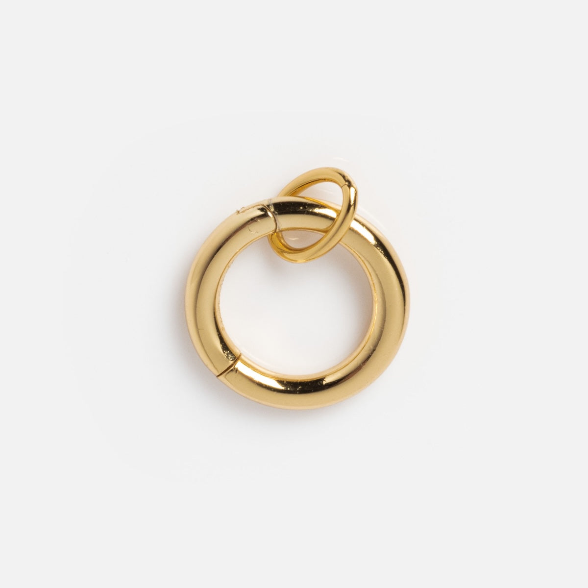 The Charm Clip is a polished 14k yellow gold circular charm with a small gold ring on top, shown against a plain white background.