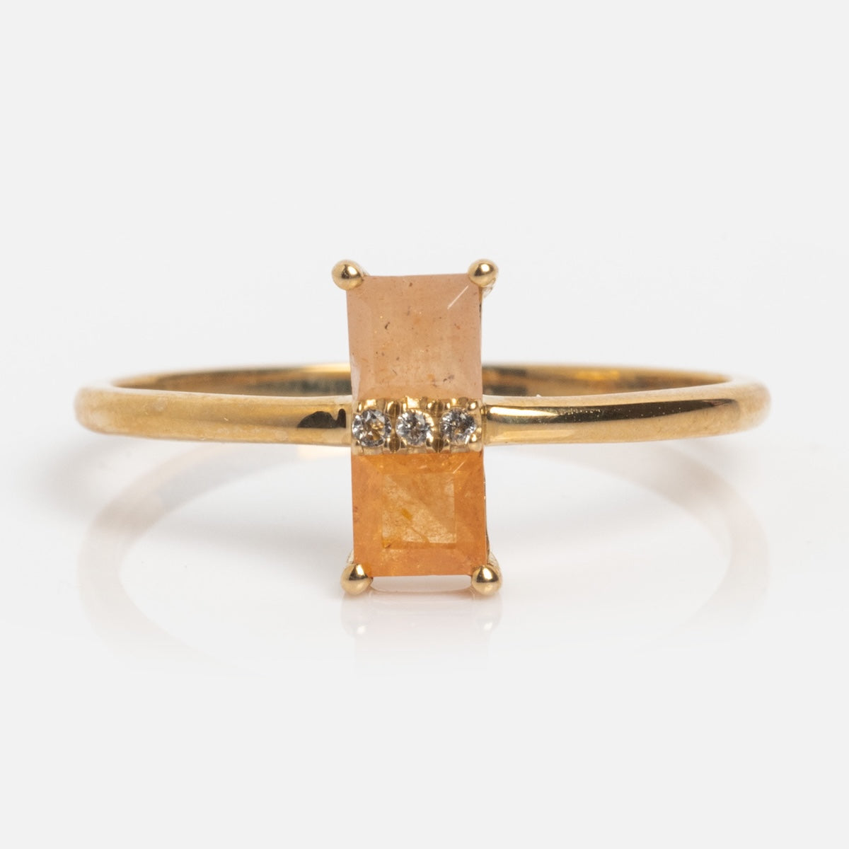 The Solid Gold Toi et Moi Ring (Sample Size 7) showcases a rectangular peach sunstone set vertically in yellow gold, accented by three small round diamonds arranged across the center.