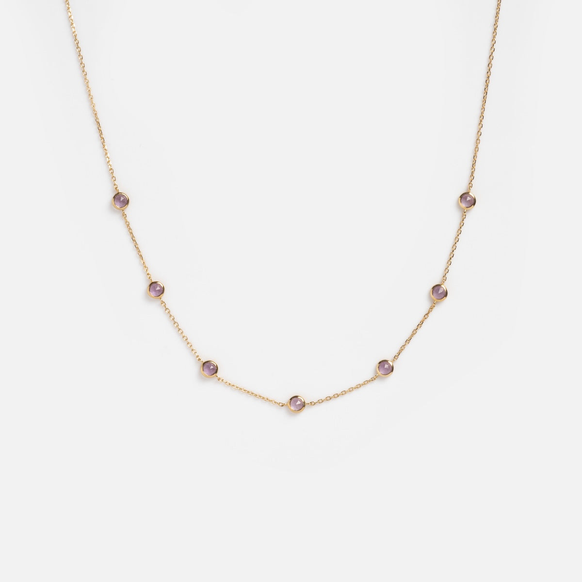 Solid Gold Birthstone Station Necklace Sample featuring evenly spaced round lab-created birthstones in 9k solid yellow gold bezels, shown against a plain white background.