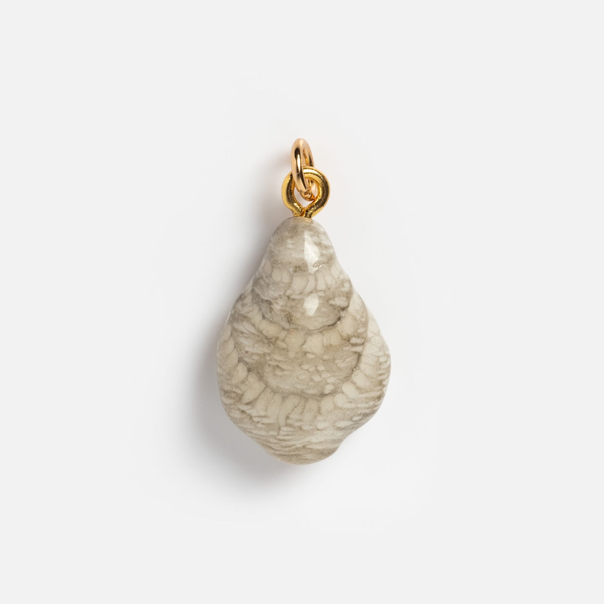 The Charms by Warm Clay Co pendant features a textured, teardrop-shaped beige stone with a gold metal loop, making it a standout necklace charm displayed on a plain white background.
