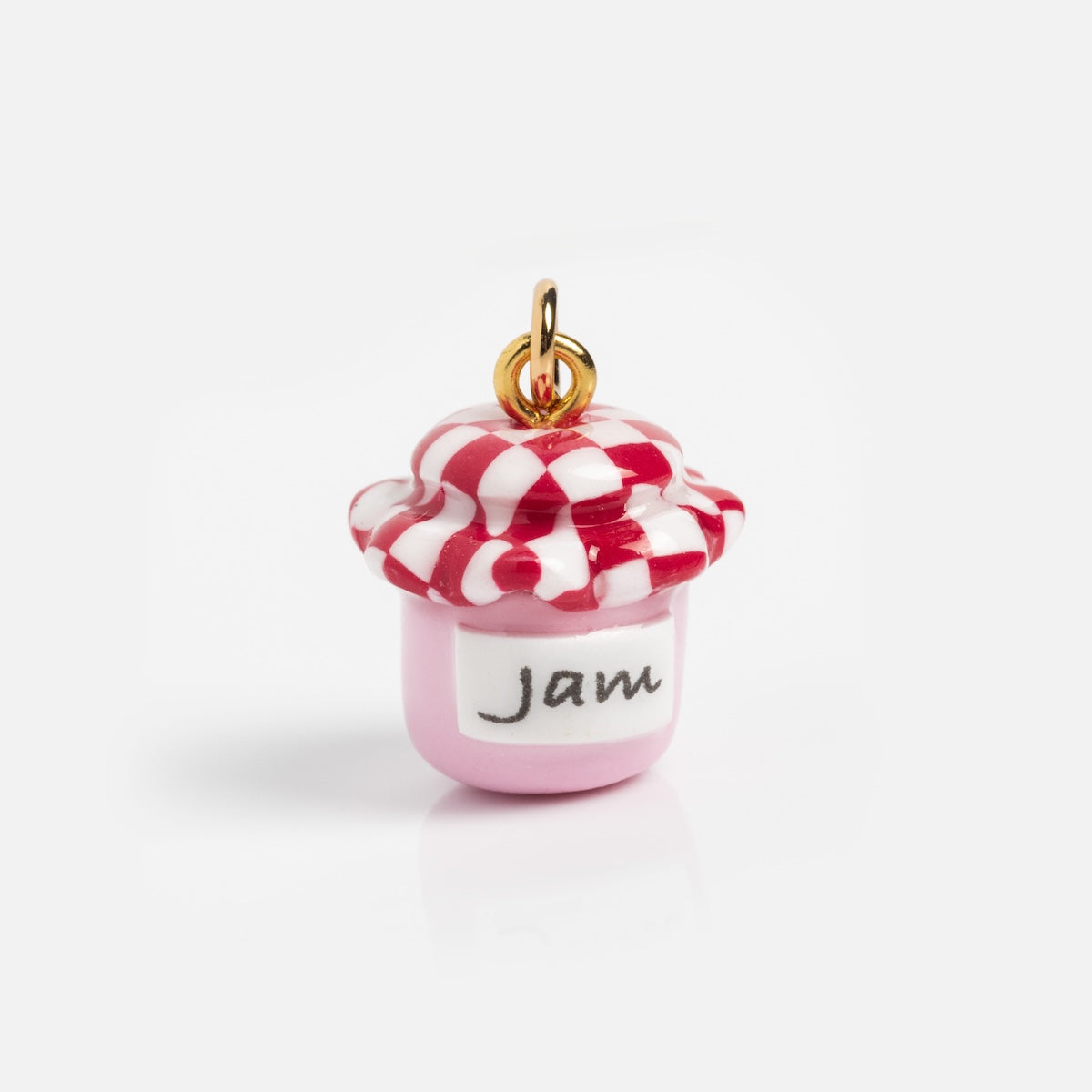 Charms by Warm Clay Co: A small, gold-plated clay charm shaped like a pink jam jar with a checkered lid and jam label—perfect for unique necklace charms or bracelets.