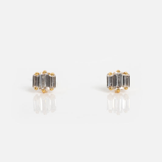 The Deco Earrings feature rectangular, vertically set clear cubic zirconia stones in 18k gold plated prongs, shown on a white background.
