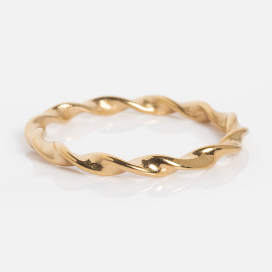 The Souvenirs Ring is a thin yellow gold band with a twisted, rope-like design, ideal for stacking and shown on a white background.