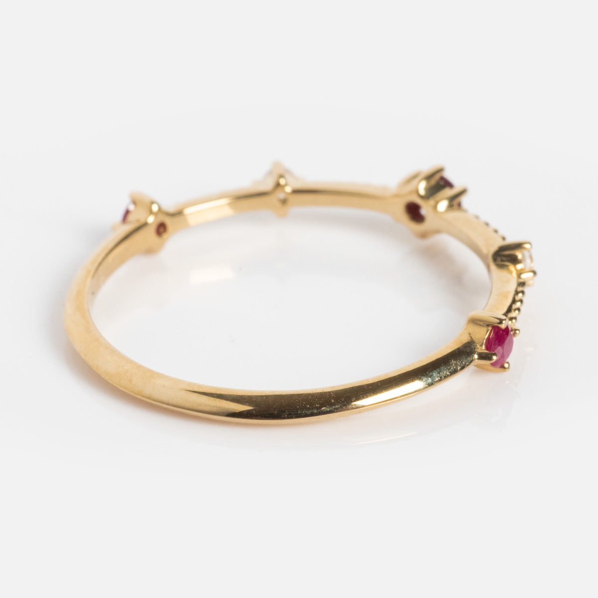 The Solid Gold 2025 July Capsule Delicate Ruby Stacking Ring features vibrant red rubies, making it a perfect birthstone piece for July or a stylish addition to your everyday jewelry collection.