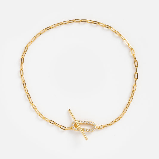 The Jade Pave Bracelet features a delicate gold paperclip-style chain with oval links and a jeweled toggle clasp adorned with sparkling clear stones, shown against a plain white background.