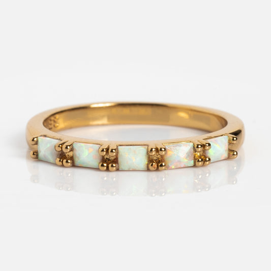 The Opal Baguette Band is a 14k gold plated stacking ring with five square-cut opal stones set in a row, each secured by gold prongs, shown on a white background.