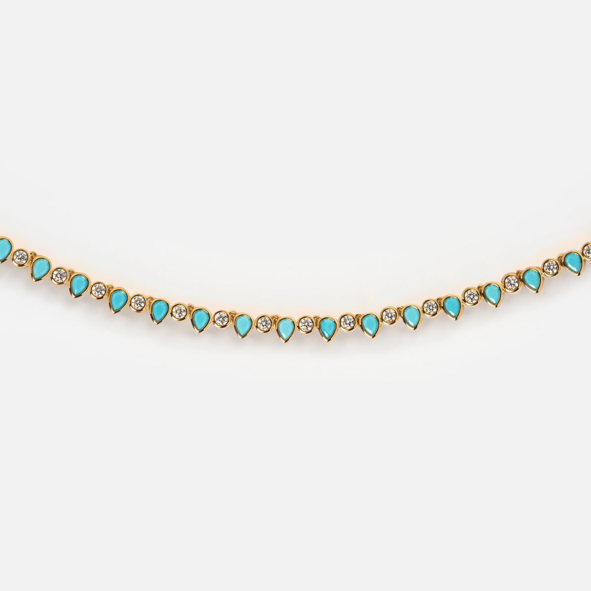 The Teardrop Tennis Necklace is a delicate 14k gold piece featuring alternating turquoise teardrop stones and round cubic zirconia crystals, showcased against a plain white background.