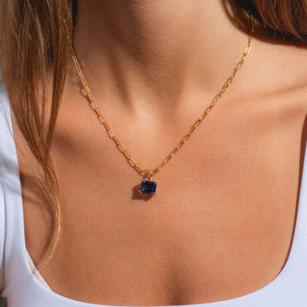 A woman wearing the Born to Shine Birthstone Necklace with a delicate paperclip chain.