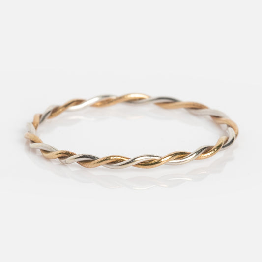 The Solid Gold Featherweight Mixed Metal Stacking Ring features delicate intertwined strands of gold and silver, showcased on a white background.