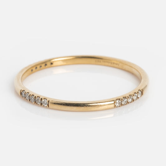 The Solid Gold Dainty Diamond Stacking Ring features small, evenly spaced lab-created diamonds set along the top half of a delicate gold band, shown on a white background.
