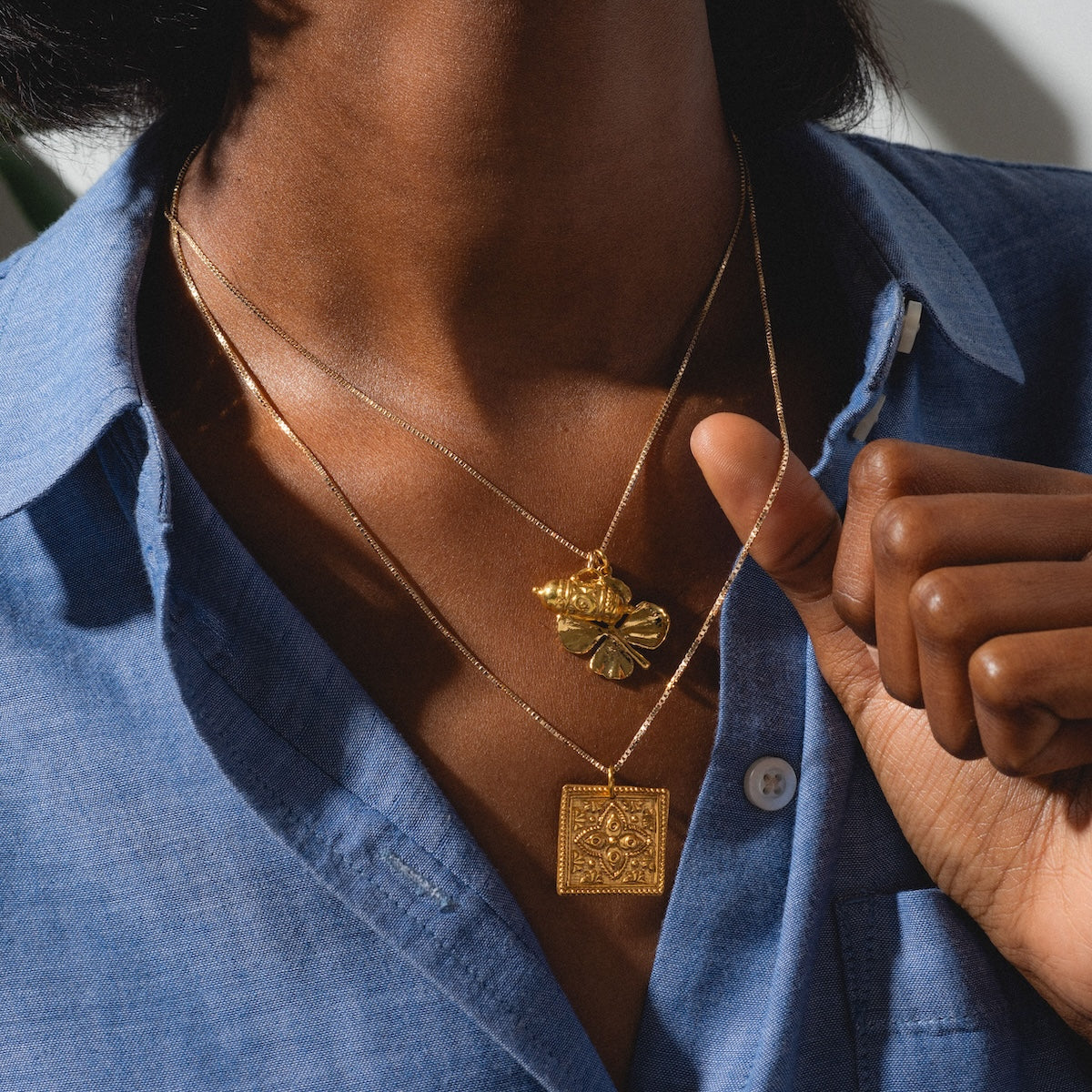 Woman Kinara, Tum, and four leaf clover charms on necklaces