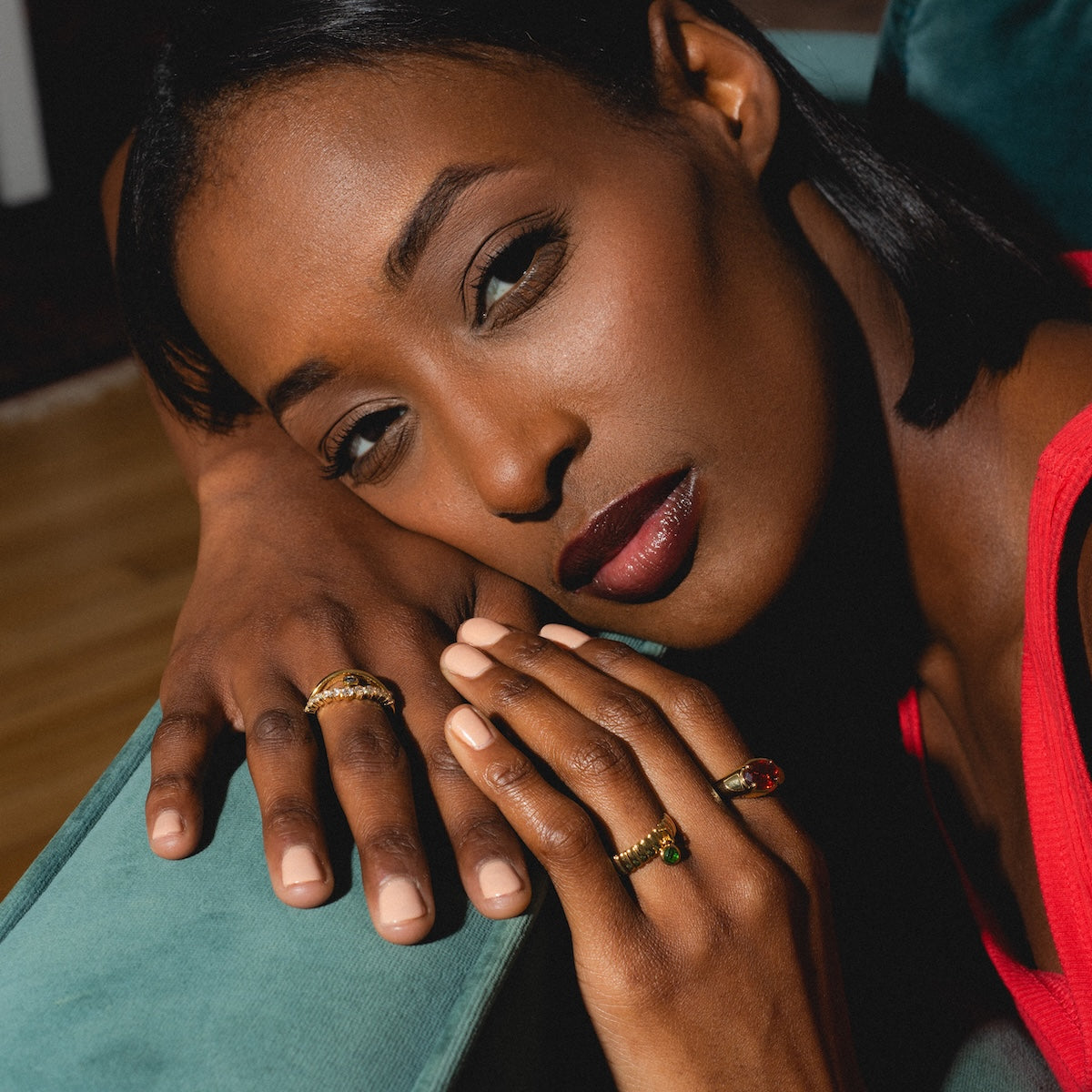 Woman with gold rings on a teal couch