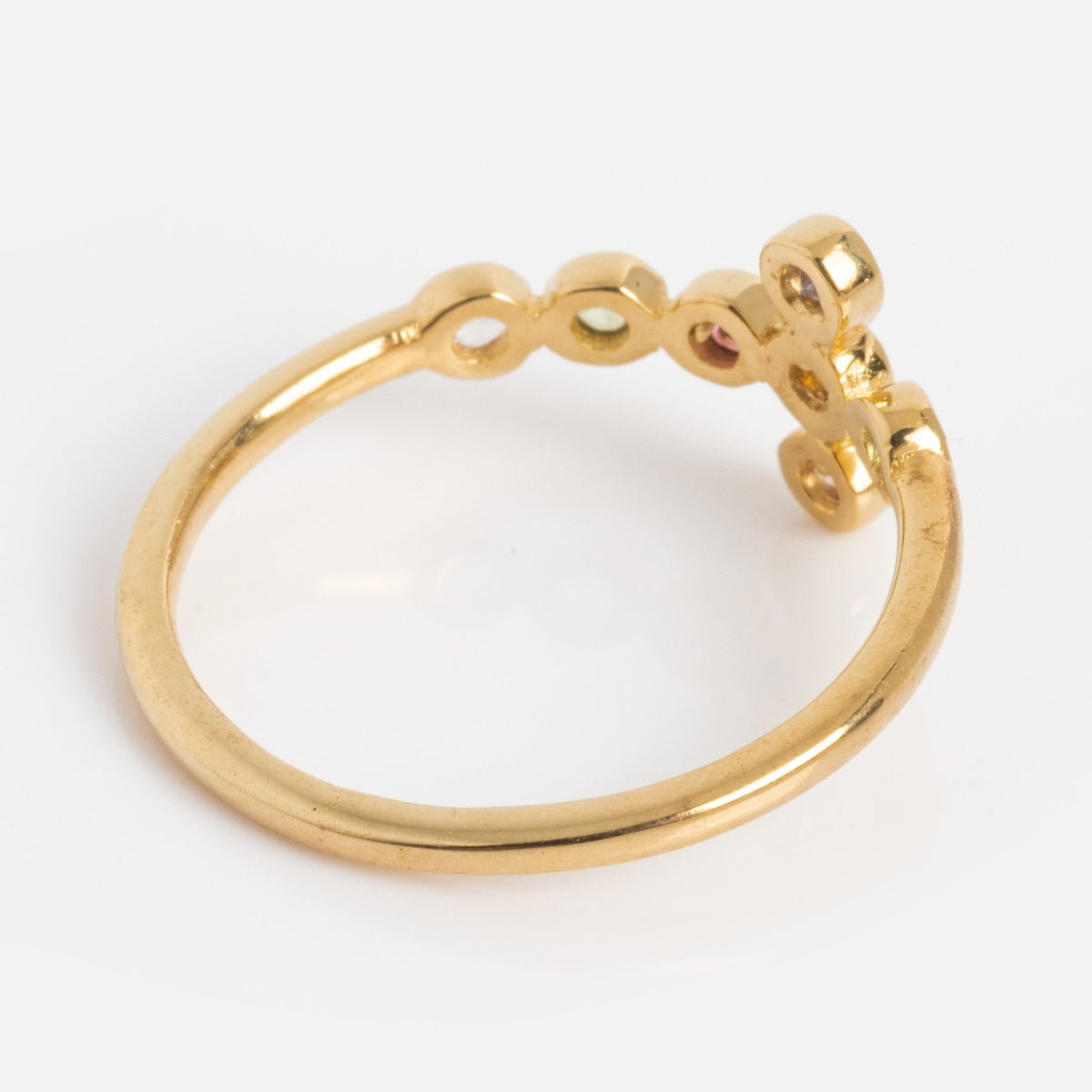 The Notre Dame Ring is a yellow gold plated ring with an open design, featuring circular loops and a decorative cluster on one side, shown on a plain white background.