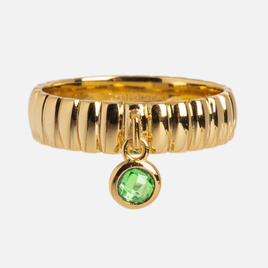 The Bold Fluted Charm Ring features a ridged texture in 14k gold plating with a small round green gem charm dangling from the center.