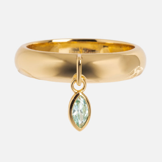 The Classic Shimmer Charm Ring features a smooth gold band with a dangling marquise-cut green gemstone set in gold—a polished Local Eclectic exclusive.