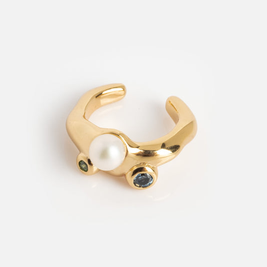 The Gem Droplet Ear Cuff is a gold ear cuff with a white pearl and two round gemstones—one green and one blue—set on a smooth, curved band, displayed against a plain white background.