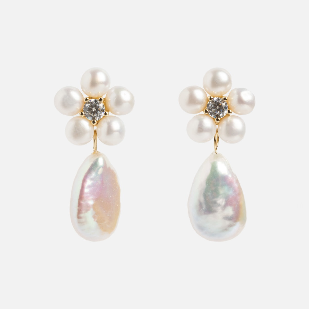 The Flower Pearl Drop Earrings feature a flower design with six round freshwater pearls, a central clear gemstone, and baroque pearl drops, all crafted in 14k gold vermeil and shown against a white background.