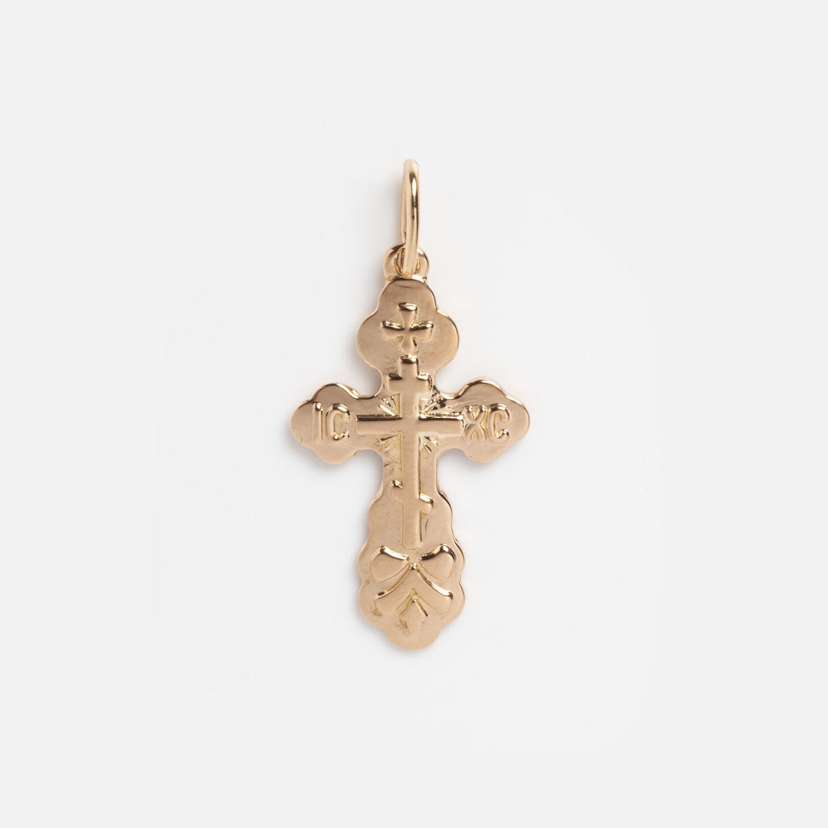 The Vintage 14k Ornate Cross Charm features rounded, decorative edges and a small loop for chains, displayed against a plain white background.