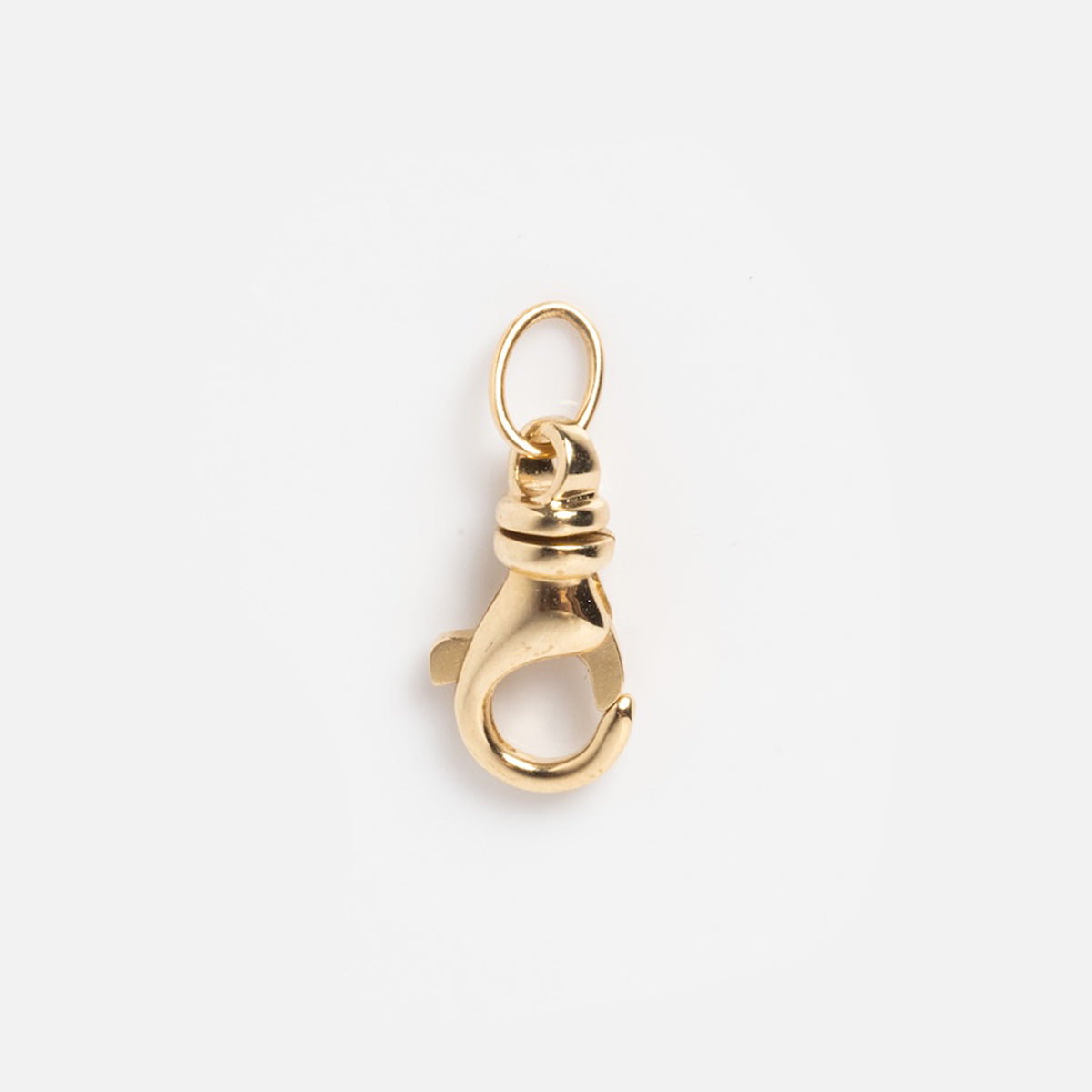 The Solid Gold Charm Clip features a small, solid gold design with a round attachment ring—ideal for bracelets or personalized necklaces—displayed on a plain white background.